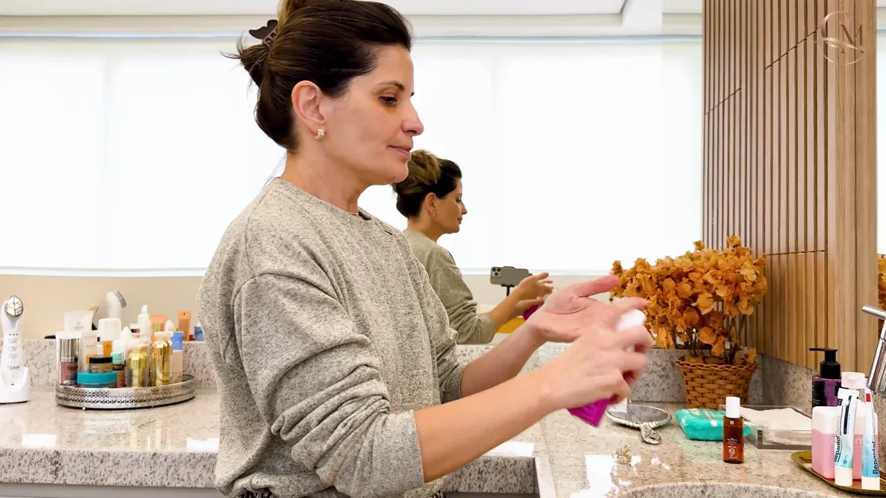 A Dra. Aline aplicando a rotina da noite no próprio rosto